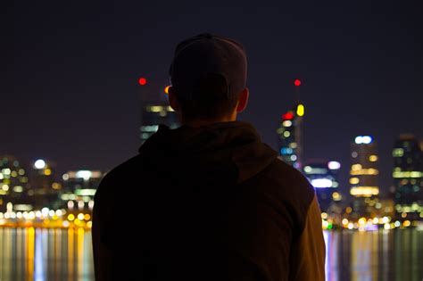 Royalty Free Photo A Man Sitting At Night Looking At The City Lights