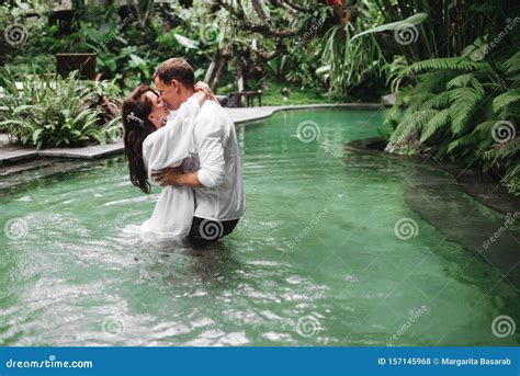 Happy Couple Kissing While Relaxing In Outdoor Spa Swimming Pool Stock