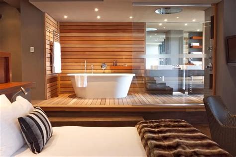 The bathtub of volcanic limestone and resin is by victoria + albert, and a ladder shelf keeps towels at a hand's reach. Modern bathroom design: Open-plan suite | Open plan bathrooms, Master bedroom bathroom, Modern ...
