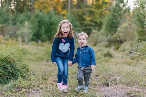 Cute Brother And Sister Holding Hands And Laughing By Jakob Lagerstedt
