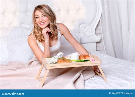 Young Blonde Woman Having Breakfast On Bed In The Morning Tasty