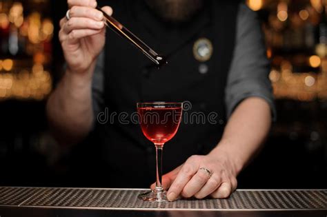 Close Up Of Bartender Dropping Cherry In Alcohol Drink Stock Image