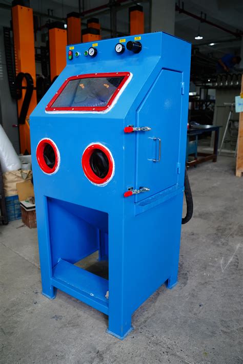 A Blue Machine With Red And Black Buttons On Its Face In A Warehouse