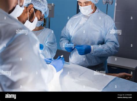 Diverse Team Of Professional Surgeons Performing Invasive Surgery On A