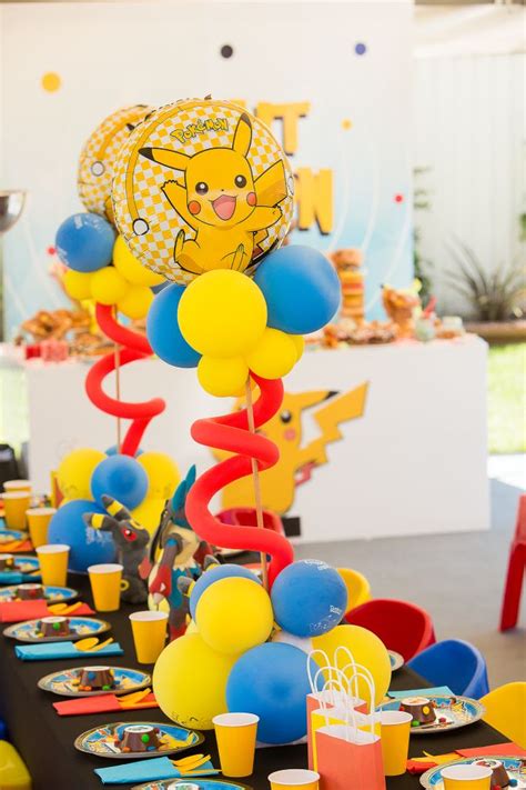 A Table Topped With Lots Of Balloons And Plates