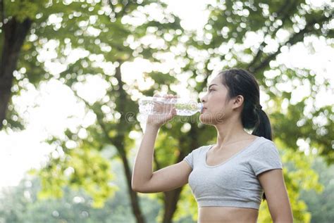 Woman Drinking Water After Exercise Is Done In The Park Stock Image