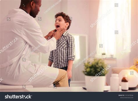 Tonsillitis Doctor Diagnosing Tonsillitis While Examining Stock Photo