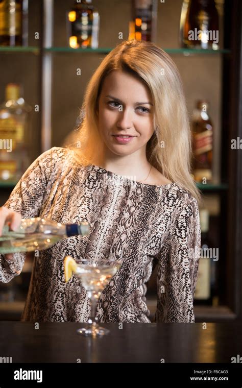 Working Blond Female Bartender Making Cocktail At Bar Counter Holding