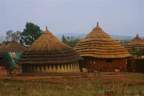 An African Village With Thatched Roofs And Grass Huts