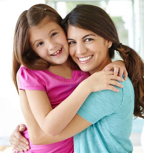 Affectionately Hugging Portrait Of A Pretty Young Mother Spending Time With Her Cute Daughter