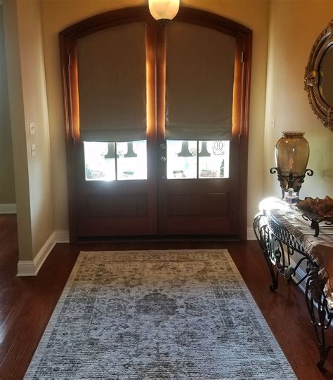 If you want to keep the window coverings to a minimum and show off the windows and trim at the same time, try leaving the top of the window exposed, and hang a curtain rod just where the curve. Custom blackout roman shades on arched front doors adds ...