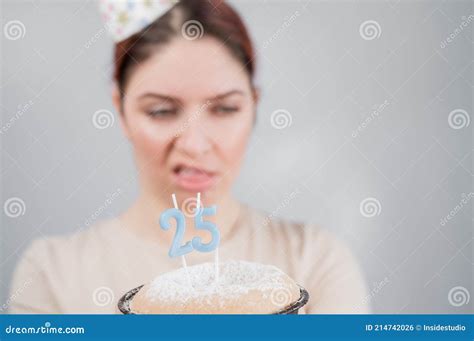 the unhappy woman is holding a cake with candles for her 25th birthday the girl is crying on