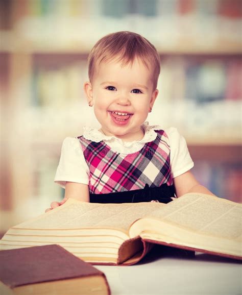 Happy Baby Girl Reading A Book In A Library Stock Photo Image 39089097