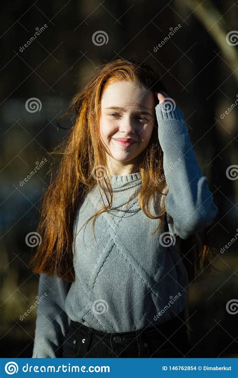 Menina Bonito Do Adolescente De Doze Anos Com O Cabelo Vermelho Impetuoso Que Levanta No Parque