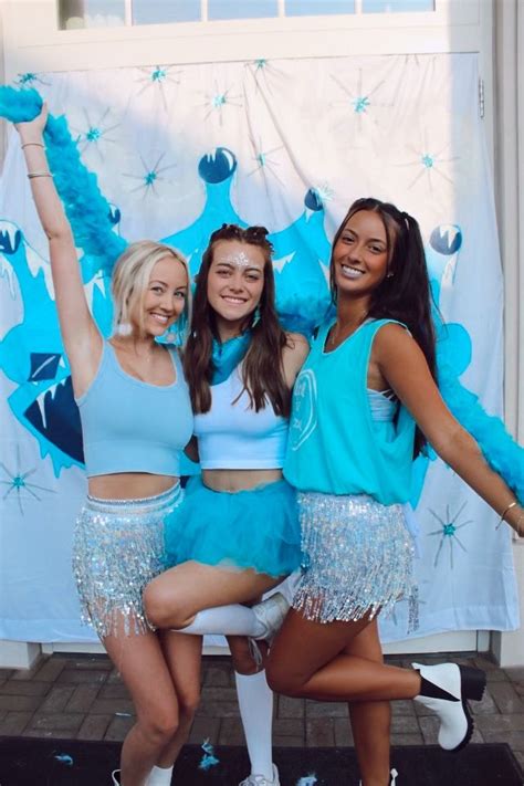 Three Girls In Blue Cheerleader Outfits Posing For The Camera