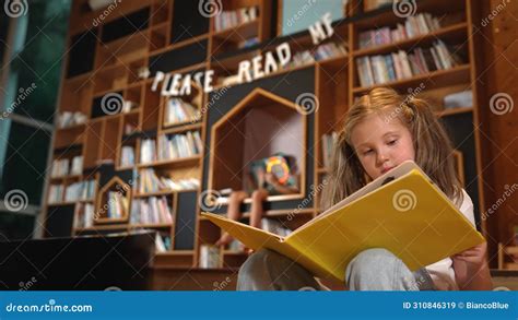 Smart Caucasian Girl Picking Reading A Book While Sitting At Library