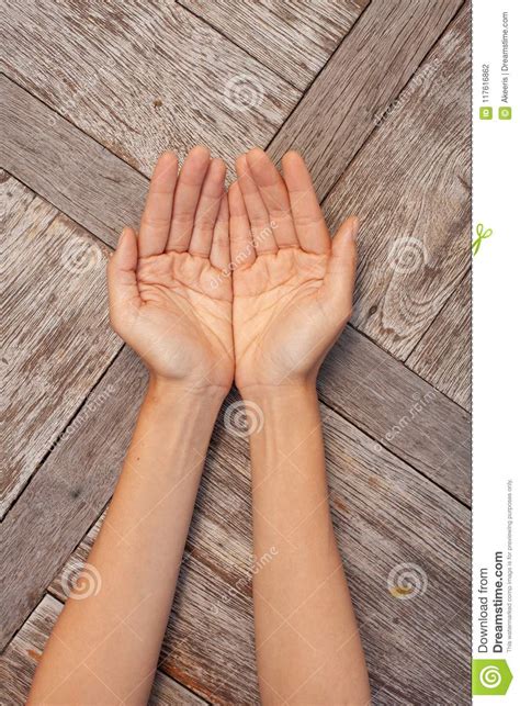 Two Female Hands Showing Open Palms On Wooden Background Stock Photo