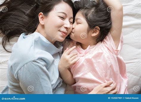 La Figlia Bacia La Guancia Di Sua Madre Ed Abbracciando Nella Camera Da Letto Famiglia Asiatica