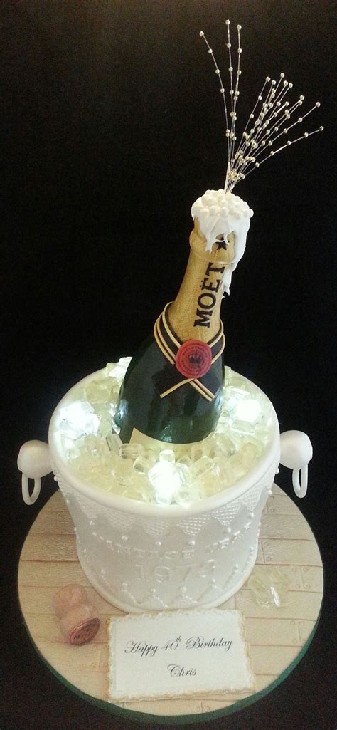 A Bottle Of Champagne Sitting In A Bucket On Top Of A Cake With