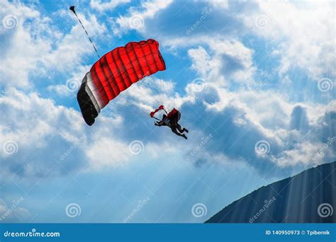Paraglider With Red Parachute Flying In The Blue Sky Stock Image