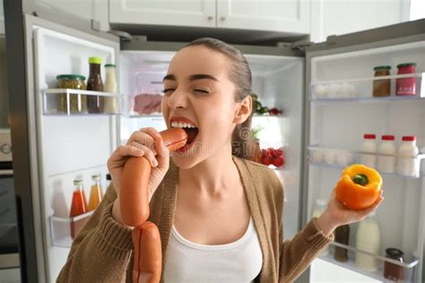 Young Woman Eating Sausage Near Refrigerator Stock Image Image Of