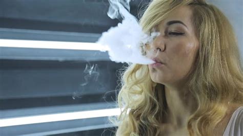 Woman Blows Smoke Rings From Electronic Hookah In Her Hand Stock Footage