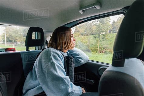 Woman Looking Out Of Window In Backseat Of Car Stock Photo Dissolve