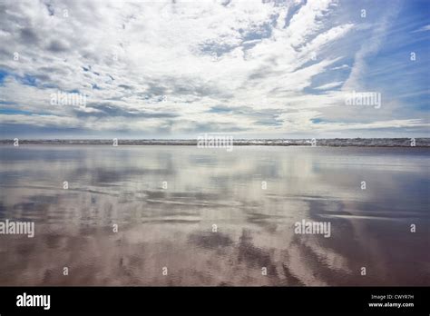 Cloudy Sky Reflected In Wet Sand At The Beach Stock Photo Alamy