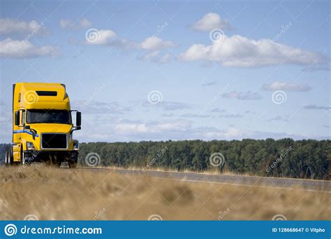 Yellow Big Rig Semi Truck Tractor With Day Cab Driving On The Road
