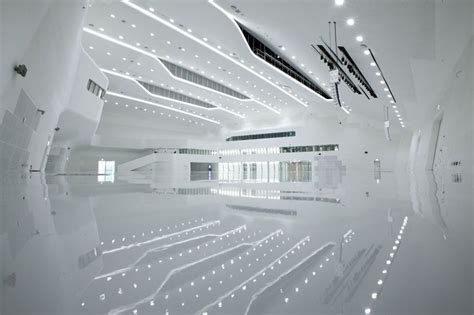 The Interior Of A Large Building With White Walls And Lights On Each