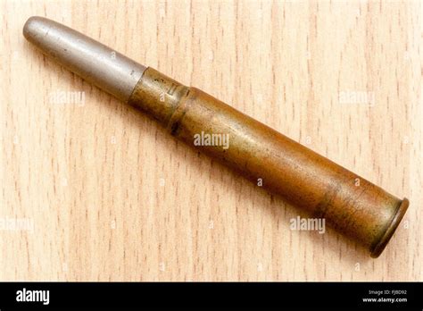 Machine Gun Bullet From The First World War Against Wood Grain Stock