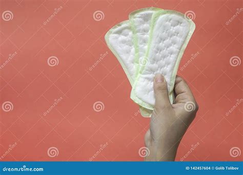 woman`s hands holding feminine hygiene pads hands of female hold menstrual pads or sanitary