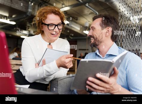 Woman Pointing At Notebook Of Her Male Partner Stock Photo Alamy