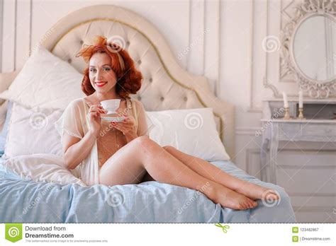 A Luxurious Pin Up Lady Dressed In A Beige Vintage Lingerie Posing In