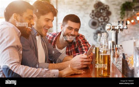 Sharing News With Smartphone And Drinking Beer In Bar Stock Photo Alamy