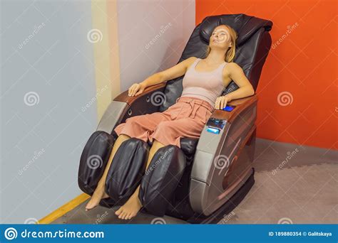 Beautiful Young Woman Relaxing On The Massage Chair In Airport Or In