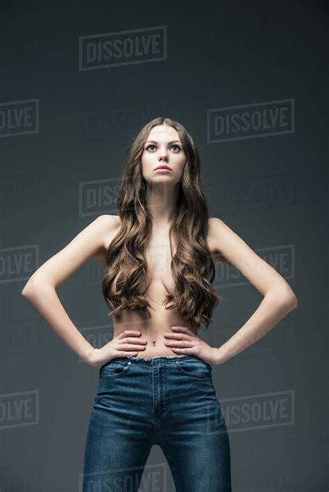 Attractive Half Naked Girl With Long Hair Posing In Jeans Isolated On Grey Stock Photo Dissolve