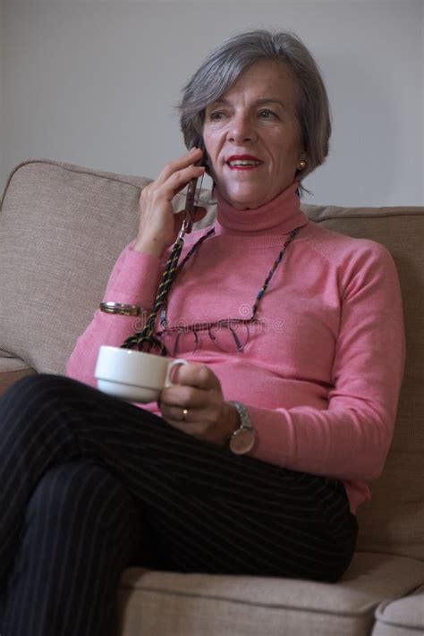 Happy Mature Woman Talking Cell Phone While Sitting On Sofa Having Coffee Stock Image Image Of