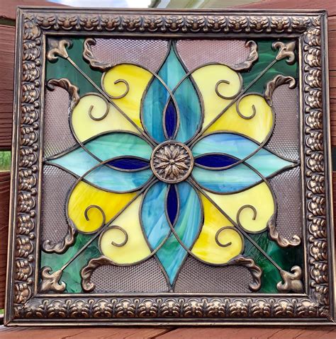 A Decorative Stained Glass Window Hanging On The Side Of A Building