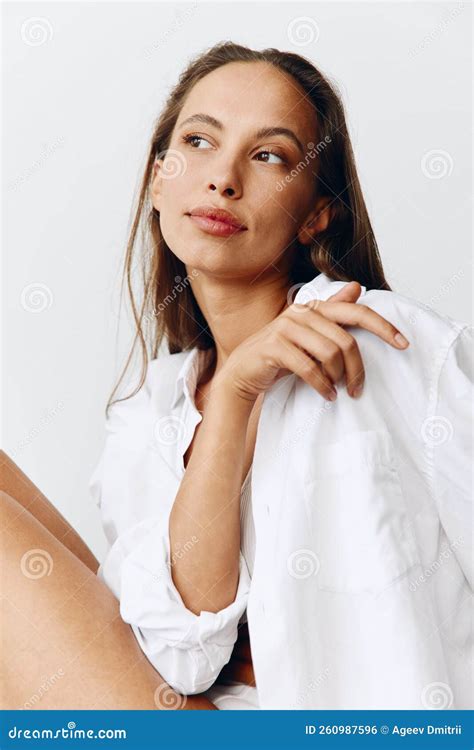 A Woman With Tanned Skin Poses On The Couch In Her Underwear And Shirt