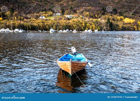 Autumn Landscape With A Wooden Blue Boat Resting At A Dock In A Fjord