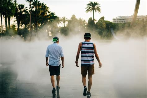 Young Men Walk Through Mist Towards Palm Trees In The City Walking