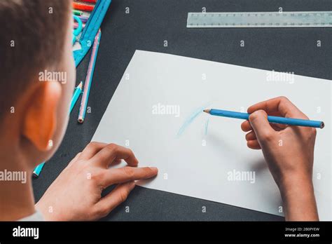 A Schoolboy Draws Pencils On White Paper Stock Photo Alamy
