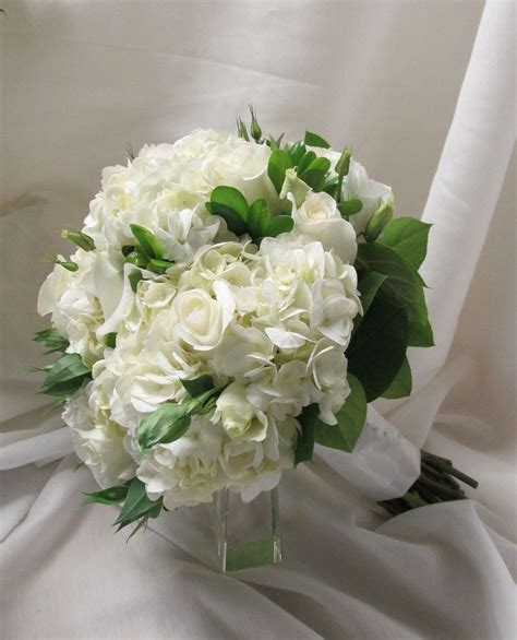 a beautiful all white bouquet of hydrangeas lisianthus and roses white bouquet wedding