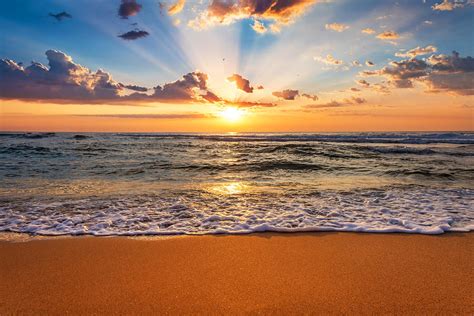 Colorful Ocean Beach Sunrise With Deep Blue Sky And Sun Rays