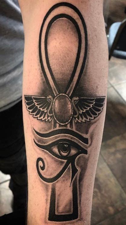 An Egyptian Tattoo Design On The Arm With An Eye And Winged Symbol In