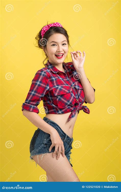 Asian Woman Retro Portrait With Pin Up Make Up And Hairstyle Posing Over Yellow Background