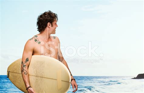 Smiling Man Holding Surfboard In Front Of Beach Stock Photo Royalty