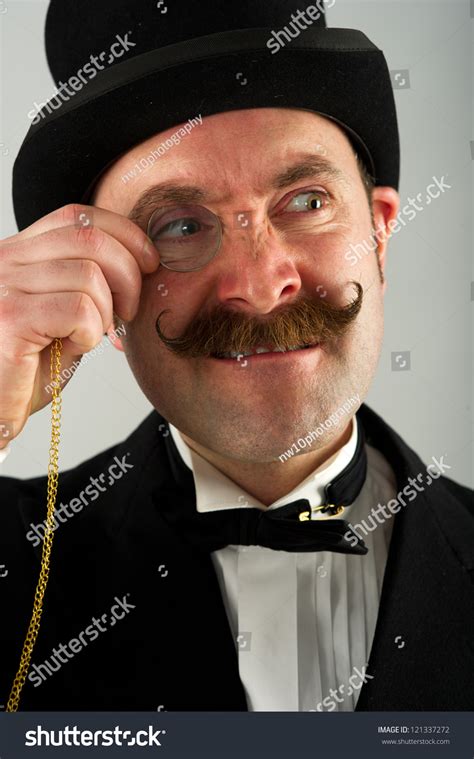 Headshot Of English Gentleman Adjusting His Monocle Which He Is Having