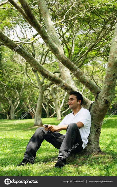 Young Man Sitting Under Tree Stock Photo By ©microstockasia 133448846